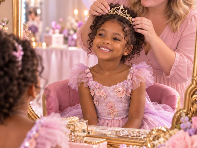 A child being crowned with a tiara at the Golden Palm Princess Experience vanity