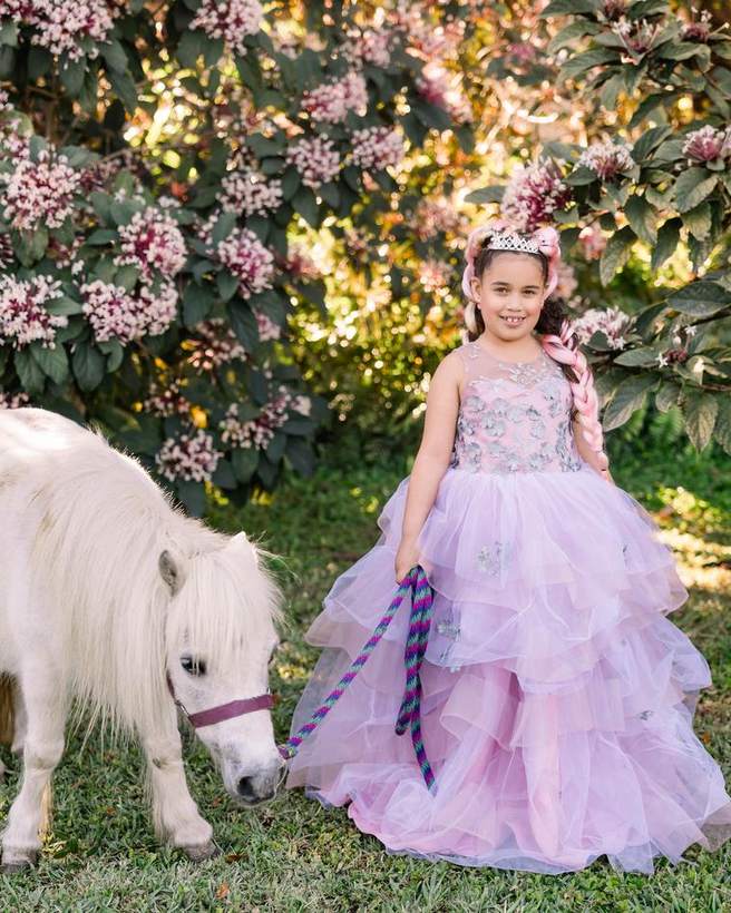A child leading a pony at a Petals and Ponies mini session