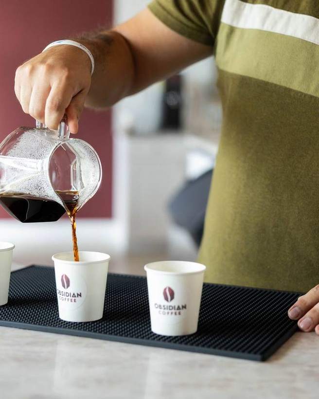 Coffee poured into three branded cups