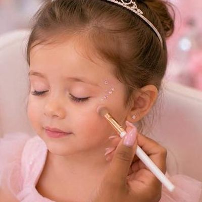 Face gems set by hand beside a guest's eye