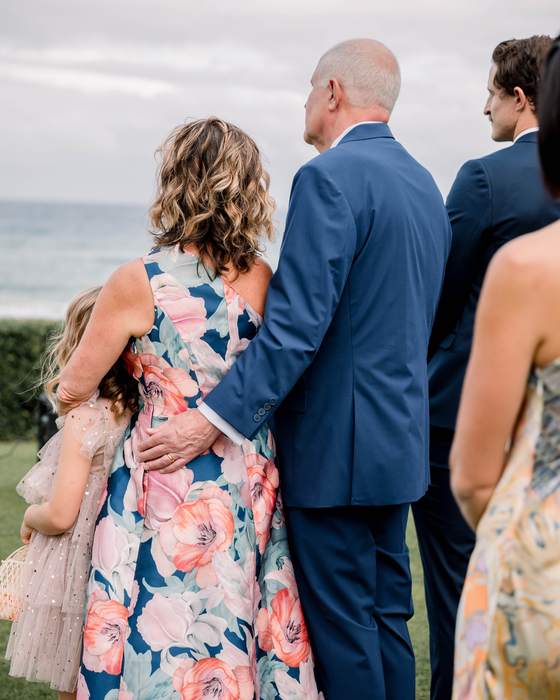 A family standing together on the lawn above the ocean before the ceremony