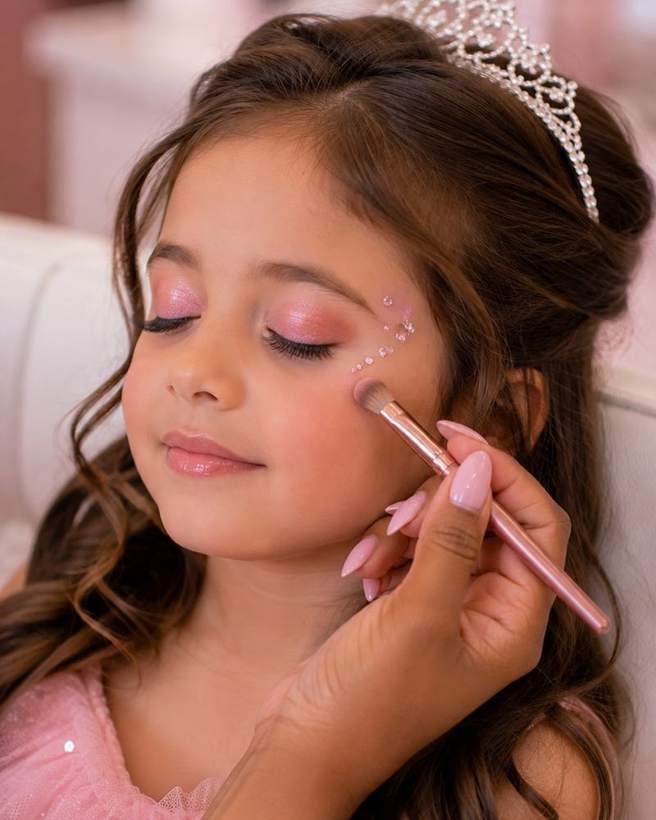 Cosmetic glitter being brushed onto a guest's cheek