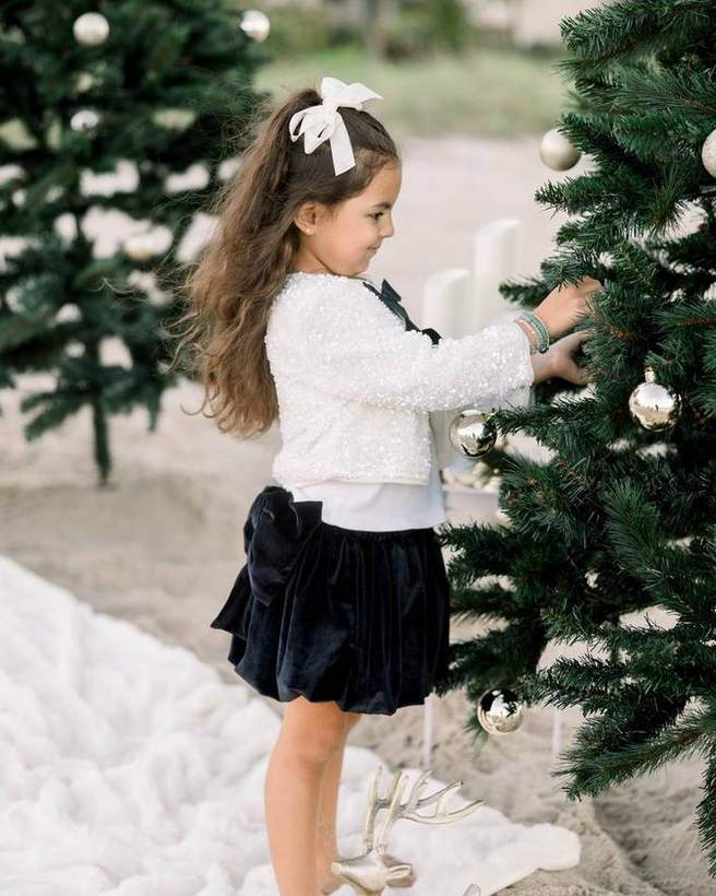 A child decorating a tree at a beach holiday session