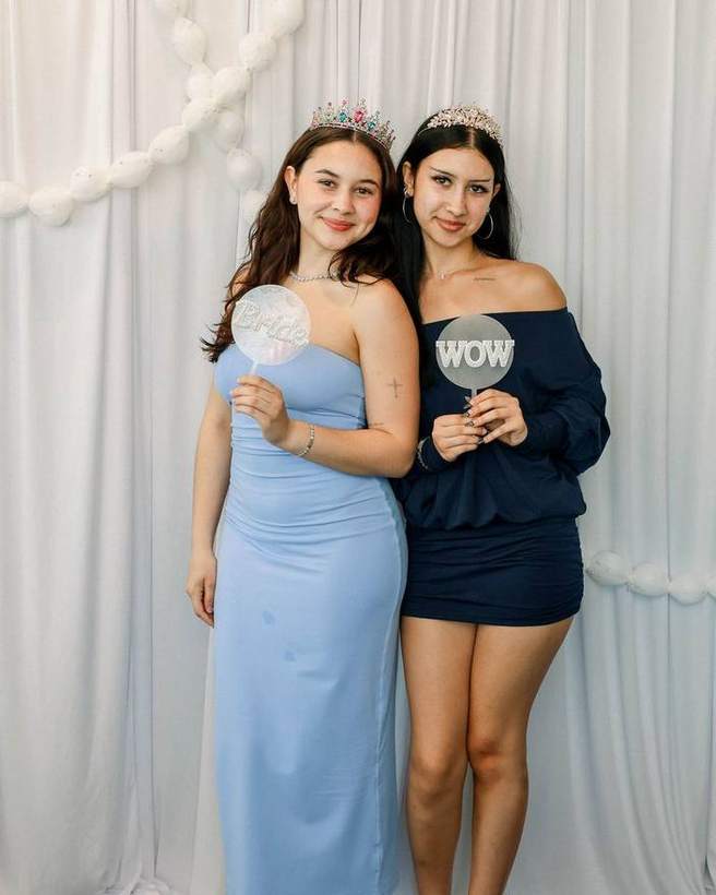 Two guests in tiaras holding props