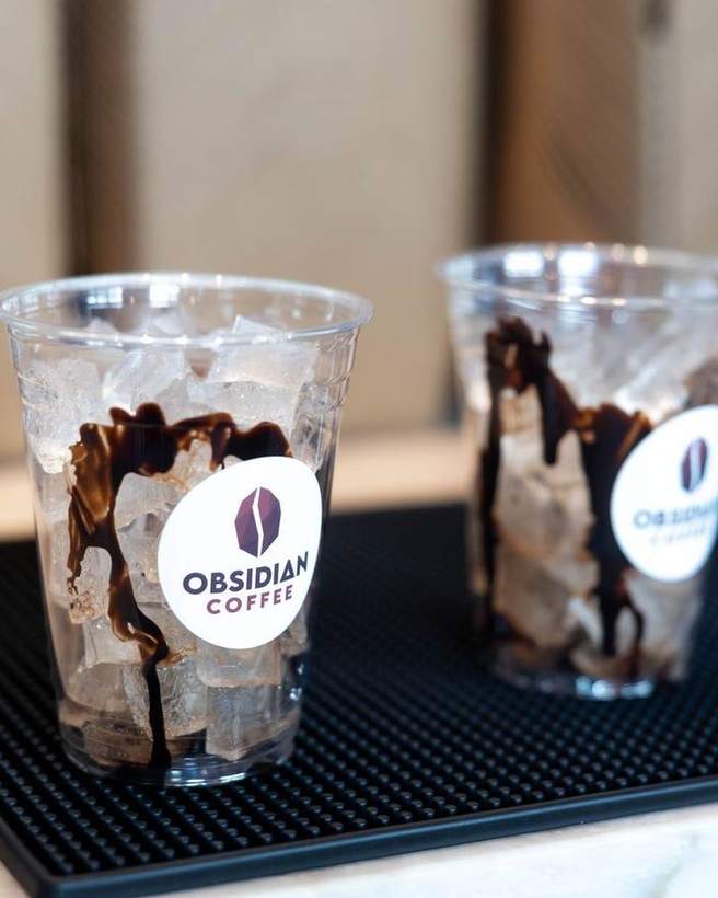 Two branded iced coffees on a bar mat