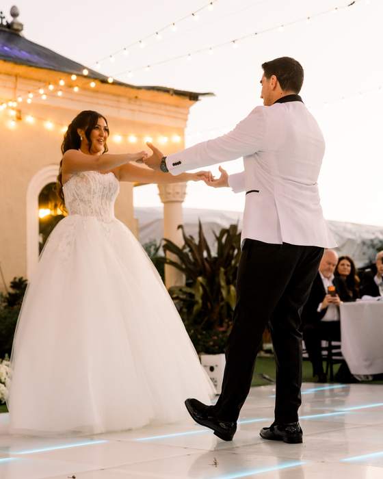 A first dance, the groom leading the bride onto the floor