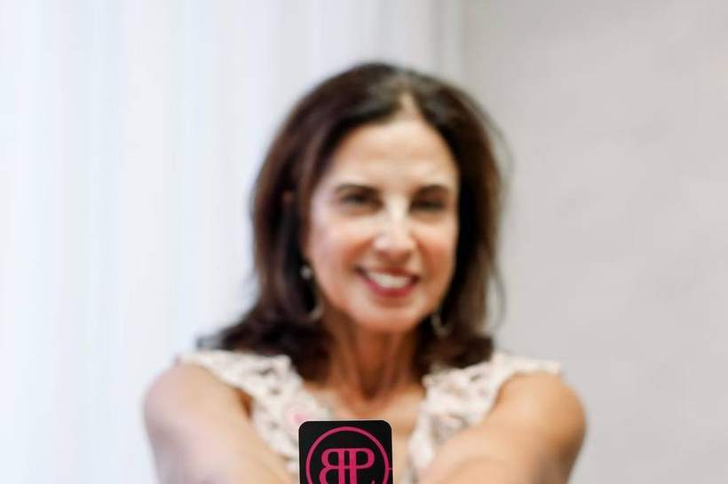 A member holding her business card at the Society headshot station