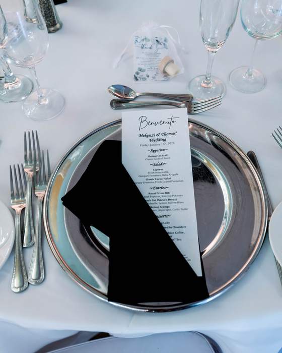 A black and silver wedding place setting with a printed menu card