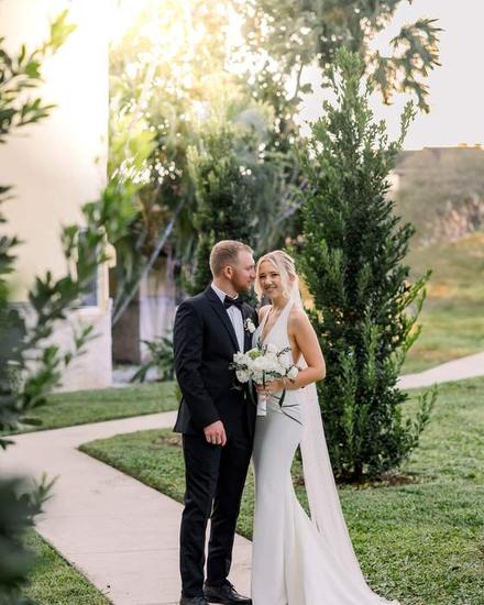 A bride and groom on a garden path in late afternoon light
