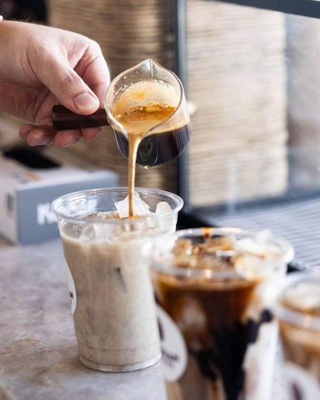 Espresso poured over ice into a branded cup