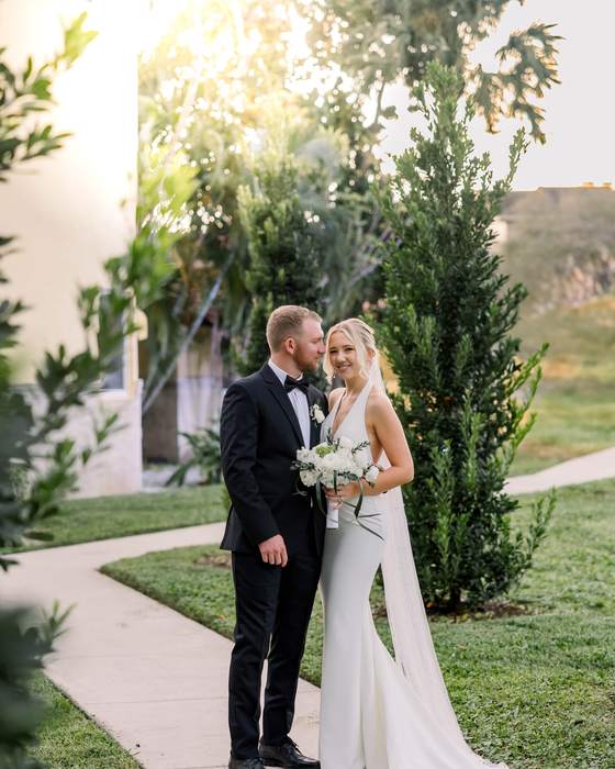 A bride and groom on a garden path in late afternoon light